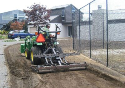 Preparing the ground beside a tennis court